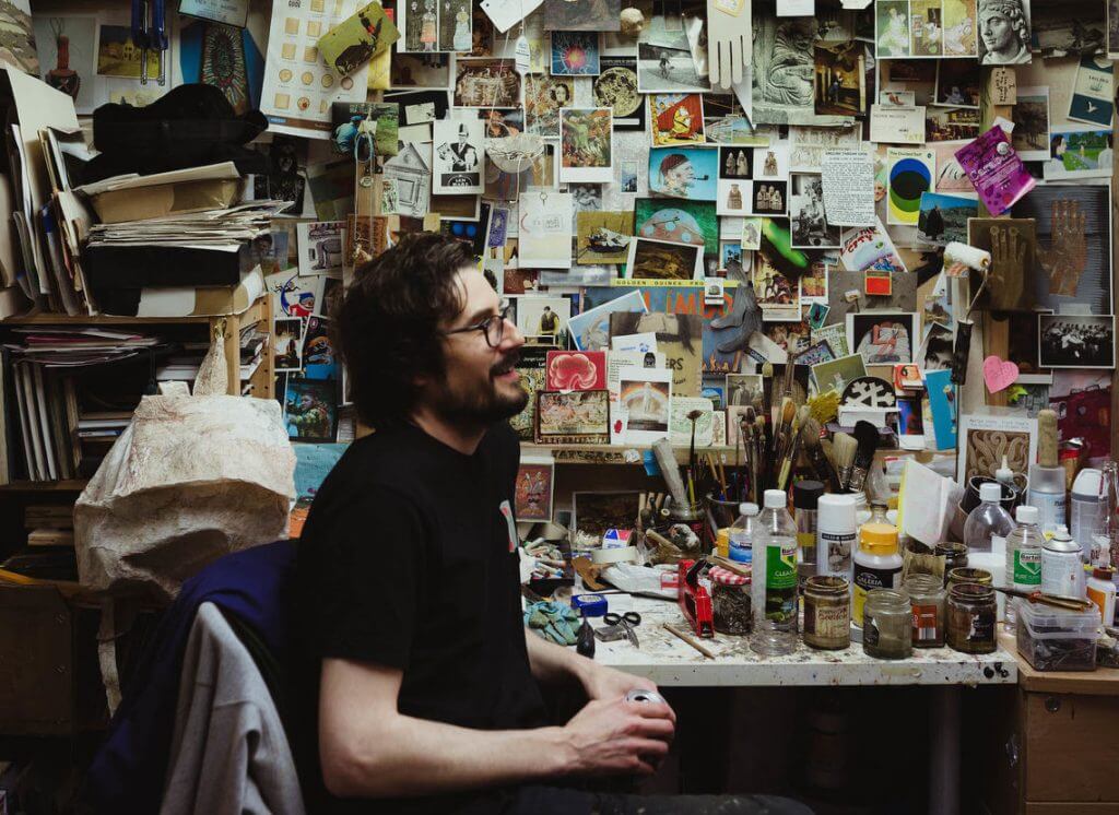 Martyn Cross sitting at his desk in his studio. Taken by Irina Silviu